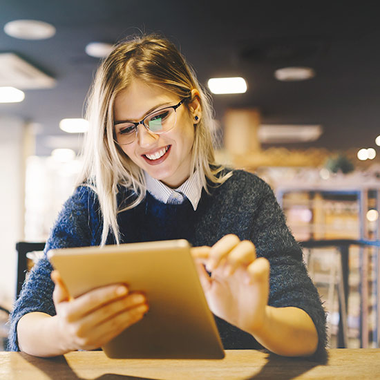 girl in library reading ebook